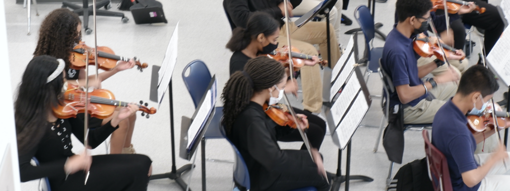 Students in performance dress play violins and violas during the spring showcase