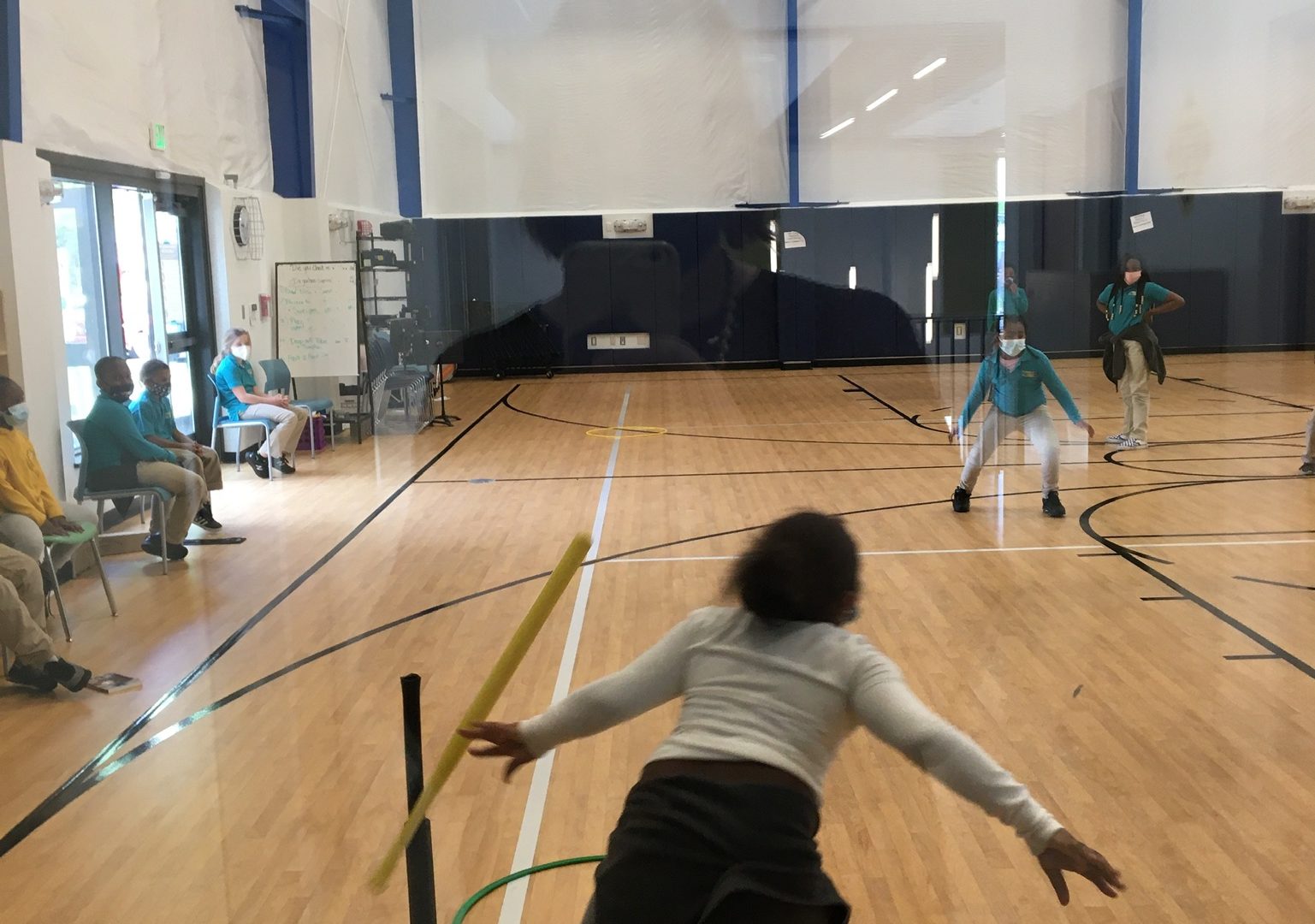 A student runs towards first base after hitting the ball