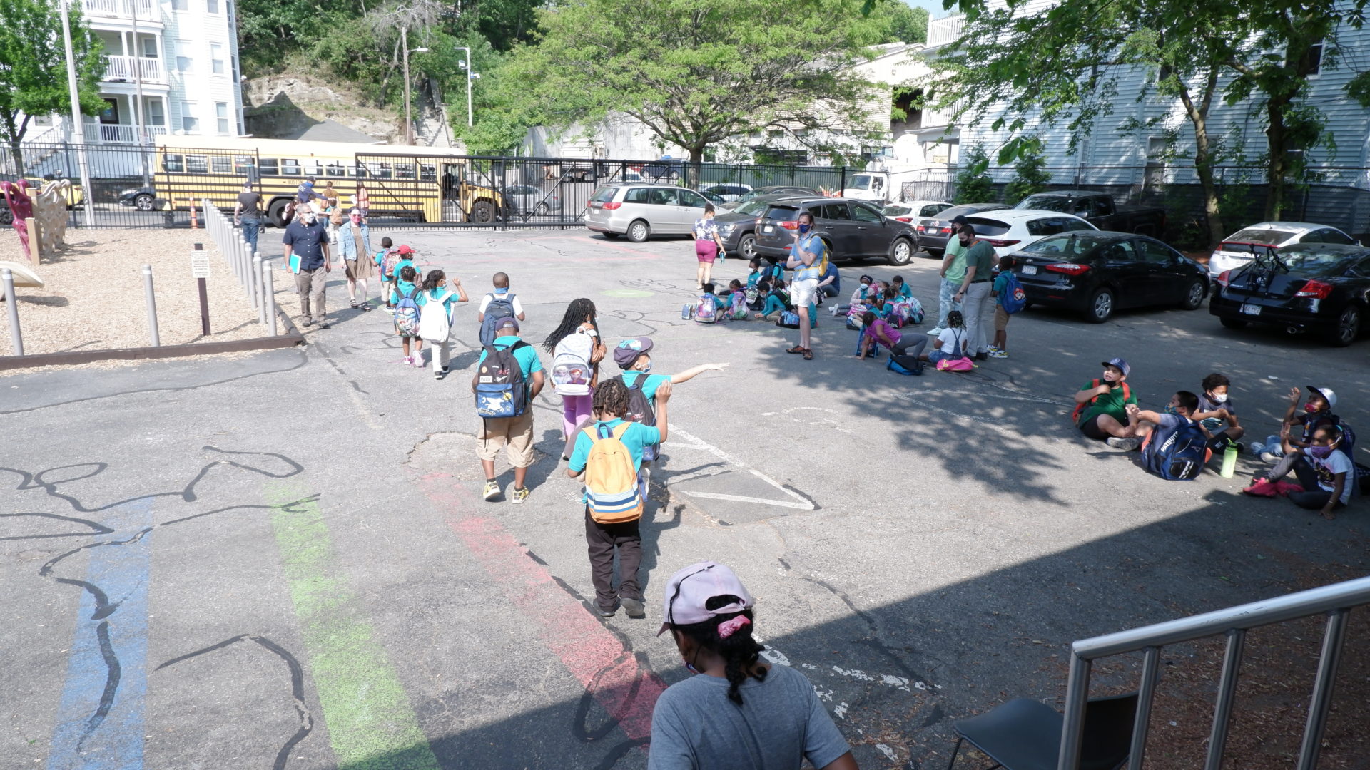 A line of students walks towards the school bus at the Lower School